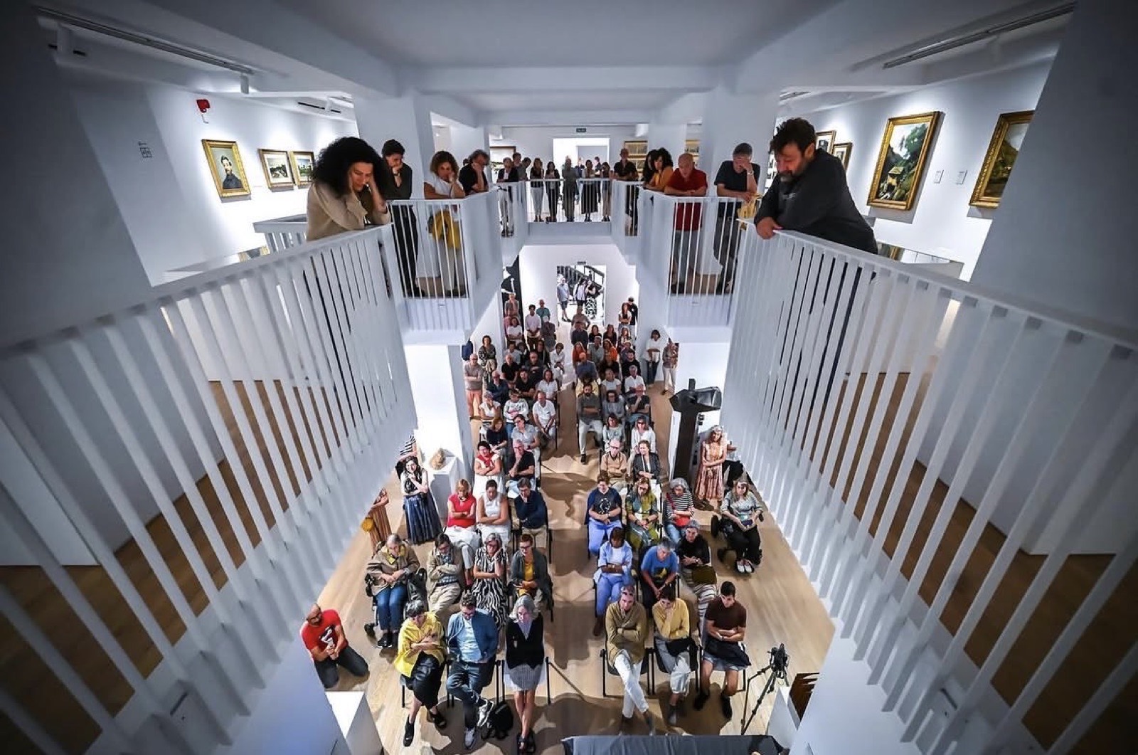 Público llenando la sala y los balcones del MAS durante un encuentro con artistas